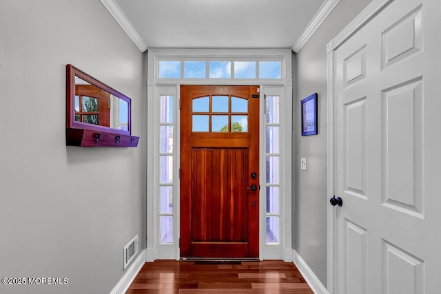 foyer featuring ornamental molding, dark wood finished floors, baseboards, and healthy amount of natural light