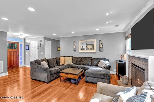 living room with light wood-type flooring, baseboards, recessed lighting, crown molding, and a fireplace