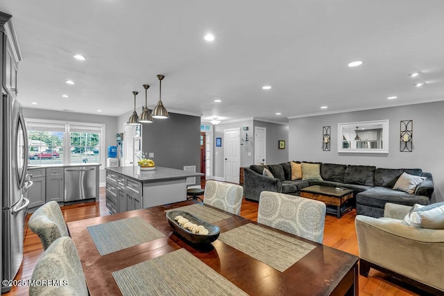 dining area with crown molding, recessed lighting, and wood finished floors