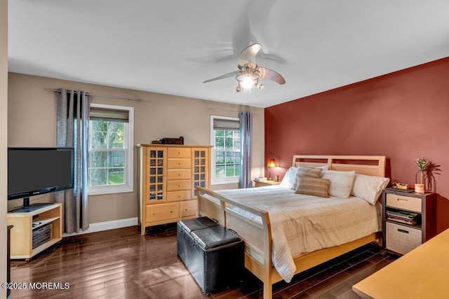 bedroom featuring dark wood-style flooring, baseboards, and a ceiling fan