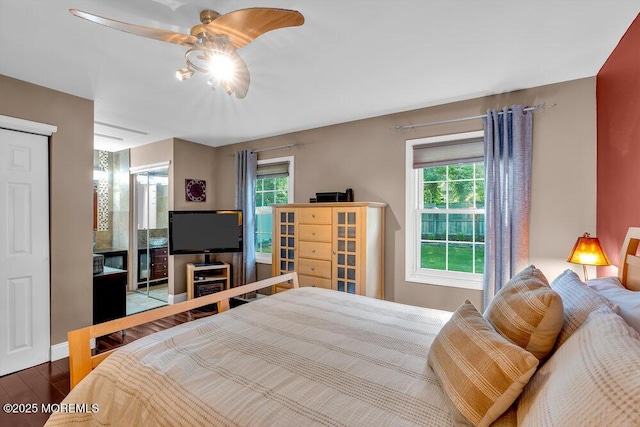 bedroom with multiple windows, wood finished floors, ceiling fan, and baseboards