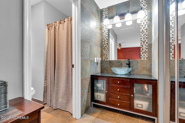 bathroom featuring tile walls, vanity, and toilet