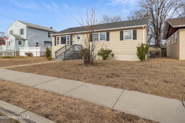 ranch-style house with central AC unit and a front yard