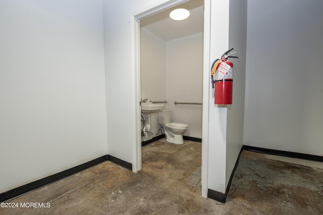 bathroom featuring concrete floors and toilet