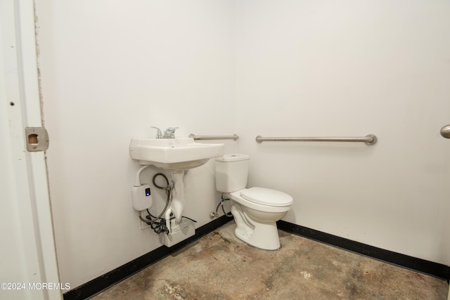 bathroom with concrete flooring and toilet