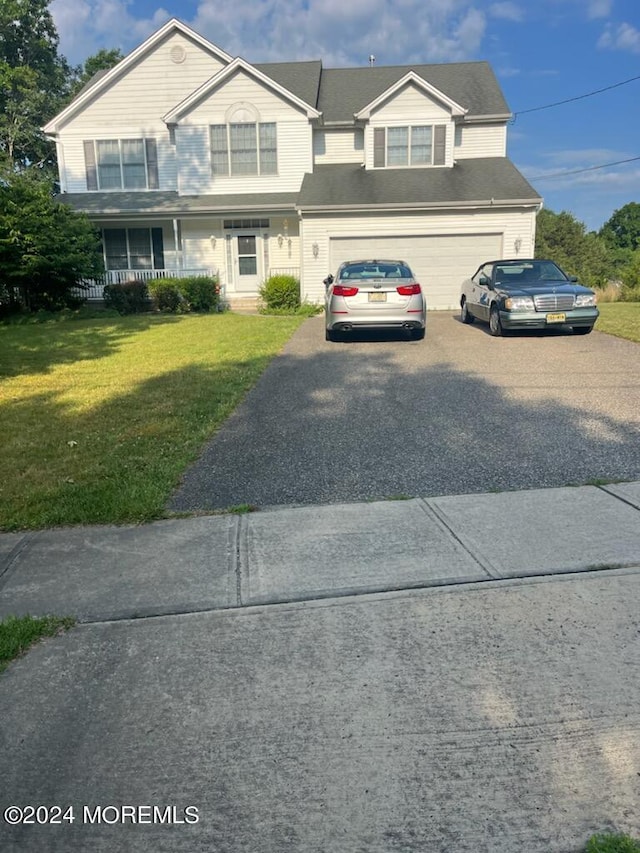 view of front of home with a porch, a garage, and a front lawn