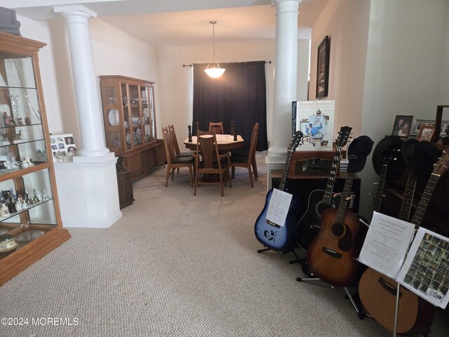 carpeted dining area featuring ornate columns