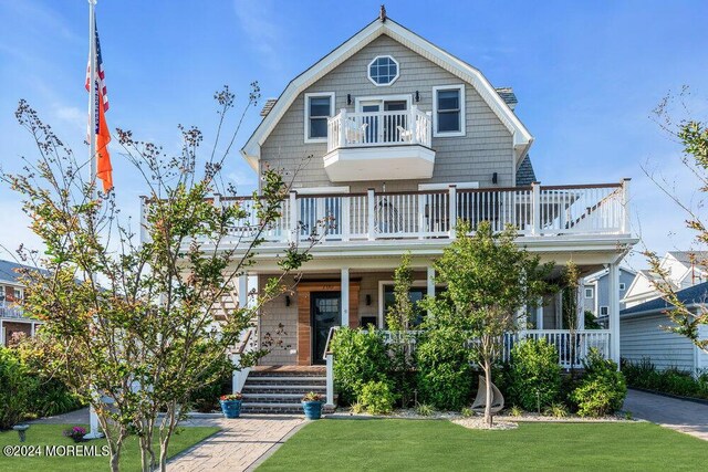 view of front of house with a front yard and a balcony