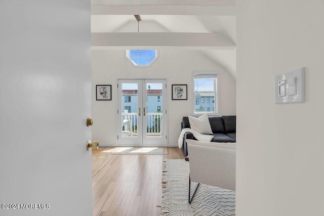 interior space featuring lofted ceiling with beams, french doors, and light wood-type flooring