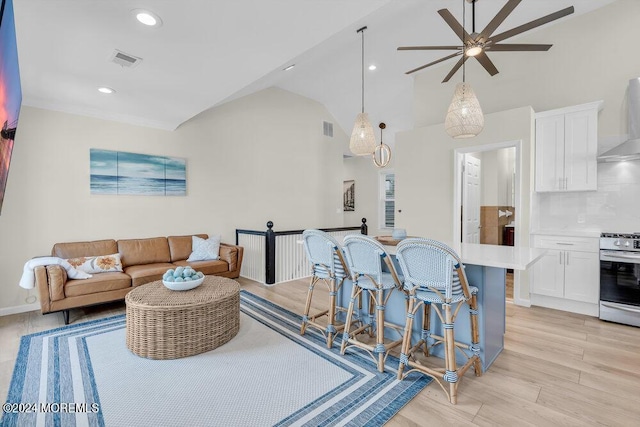 living room with high vaulted ceiling and light wood-type flooring