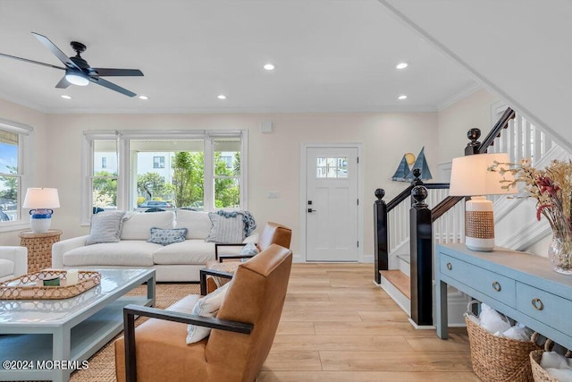 living room featuring crown molding, ceiling fan, light hardwood / wood-style flooring, and a wealth of natural light