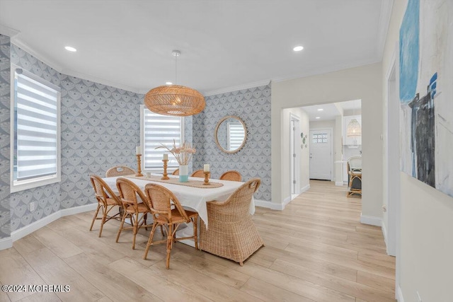 dining space with crown molding and light hardwood / wood-style floors