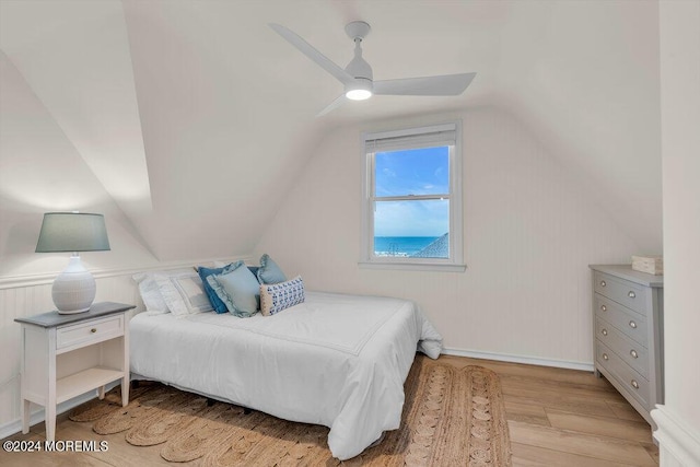 bedroom with ceiling fan, lofted ceiling, and light wood-type flooring