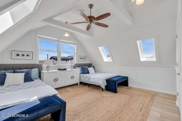 bedroom with ceiling fan, lofted ceiling with skylight, and light hardwood / wood-style floors