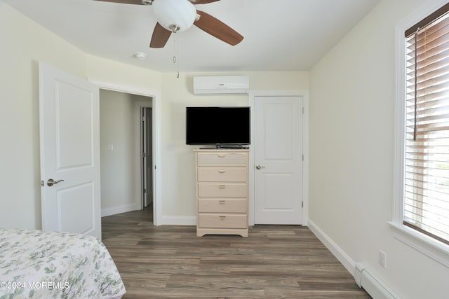 bedroom featuring dark hardwood / wood-style flooring, a wall unit AC, ceiling fan, and a baseboard heating unit