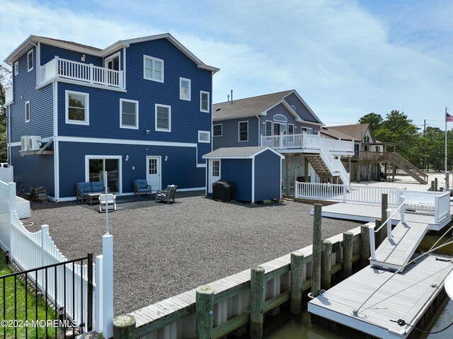 rear view of house featuring a shed, a balcony, and a deck