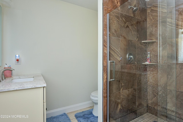 bathroom featuring tile patterned floors, vanity, toilet, and an enclosed shower