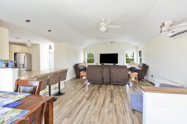 living room featuring ceiling fan, light wood-type flooring, and lofted ceiling