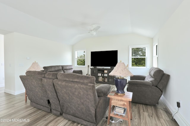 living room featuring ceiling fan, lofted ceiling, and light hardwood / wood-style flooring