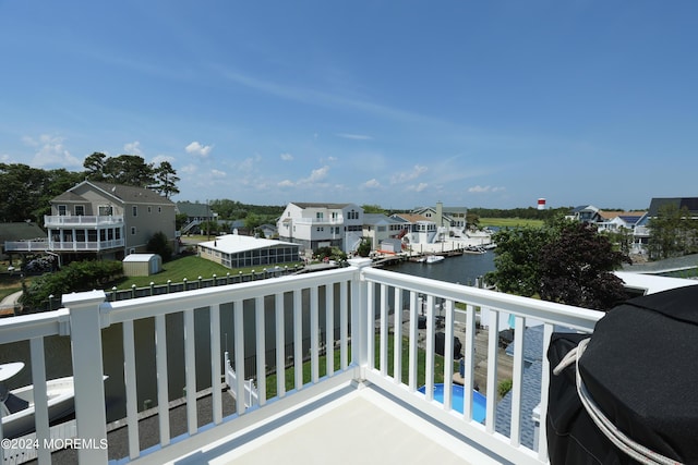 balcony with a water view and grilling area