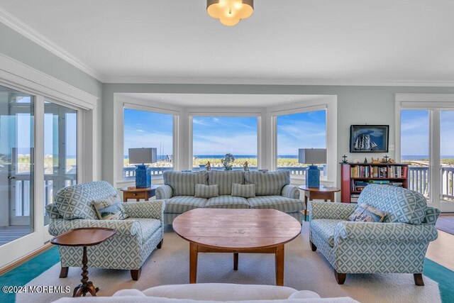 living room with a water view and crown molding