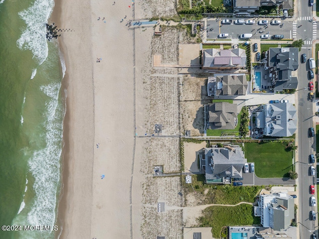 drone / aerial view featuring a water view and a view of the beach