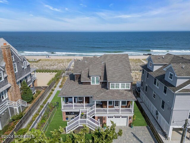 birds eye view of property with a water view and a beach view