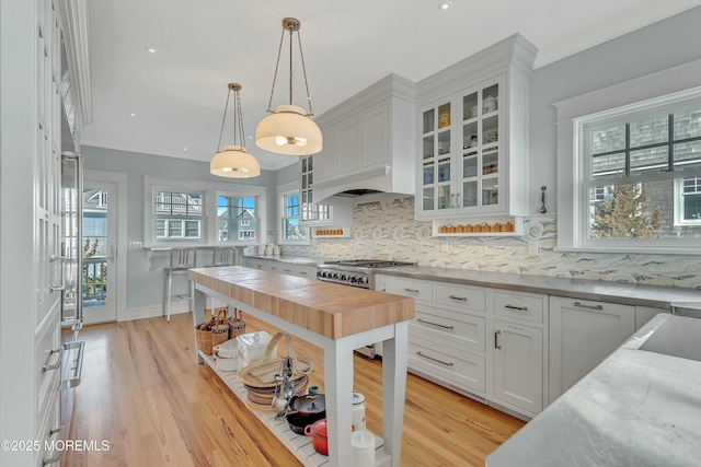 kitchen with backsplash, a healthy amount of sunlight, white cabinetry, and hanging light fixtures