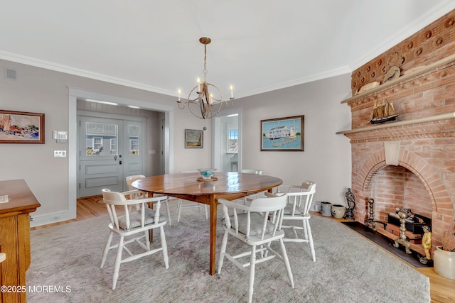 dining room featuring a chandelier, ornamental molding, and light hardwood / wood-style flooring