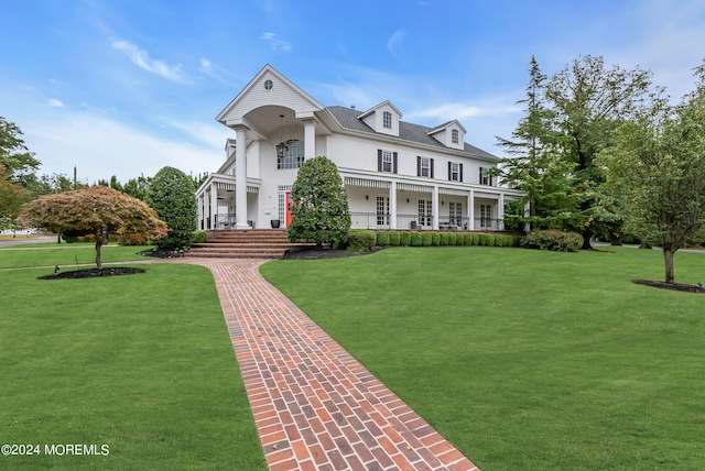 view of front of house with covered porch and a front yard