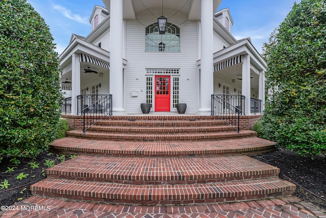 entrance to property with covered porch and ceiling fan