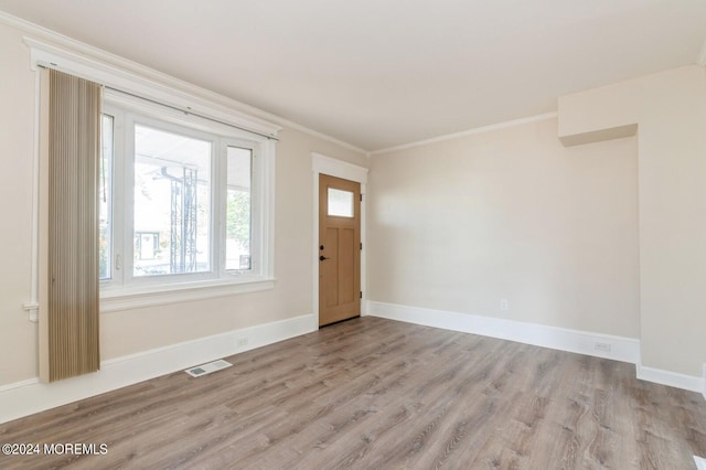 foyer featuring light hardwood / wood-style flooring and crown molding