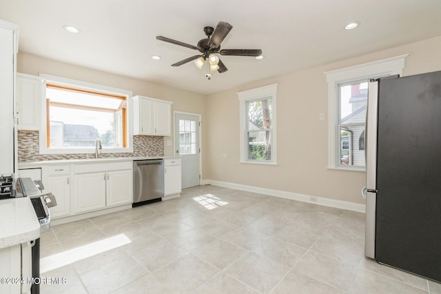 kitchen featuring ceiling fan, white cabinets, light tile patterned flooring, tasteful backsplash, and stainless steel appliances