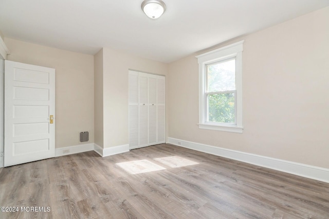 unfurnished bedroom featuring a closet and light hardwood / wood-style floors