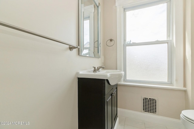 bathroom featuring vanity, toilet, and a wealth of natural light