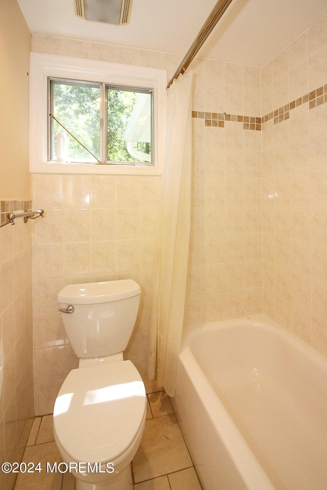 bathroom featuring shower / bath combo with shower curtain, tile patterned flooring, tile walls, and toilet