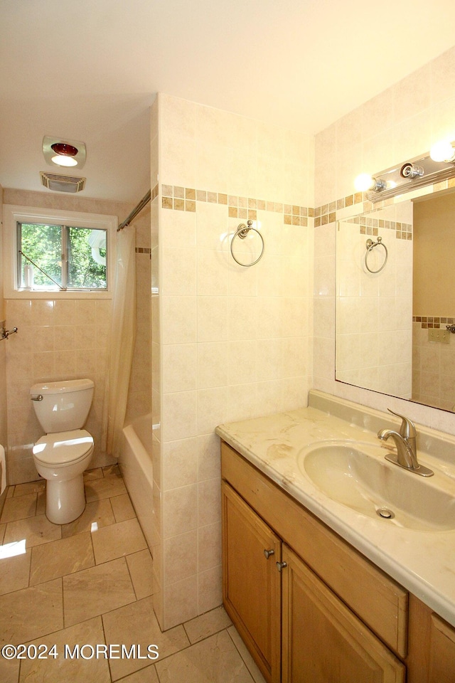 full bathroom featuring vanity, tile patterned floors, shower / bath combination with curtain, toilet, and tile walls