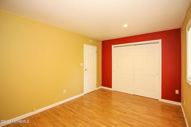 unfurnished bedroom featuring a closet and hardwood / wood-style flooring