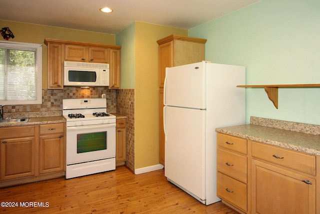 kitchen with decorative backsplash, white appliances, light hardwood / wood-style floors, and sink