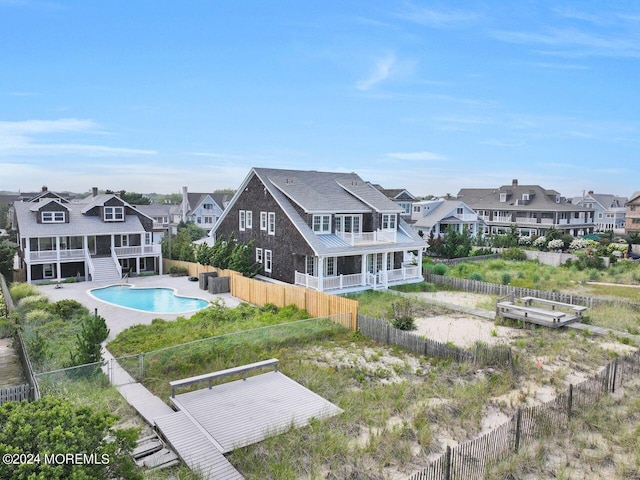 rear view of house featuring a fenced in pool and a sunroom