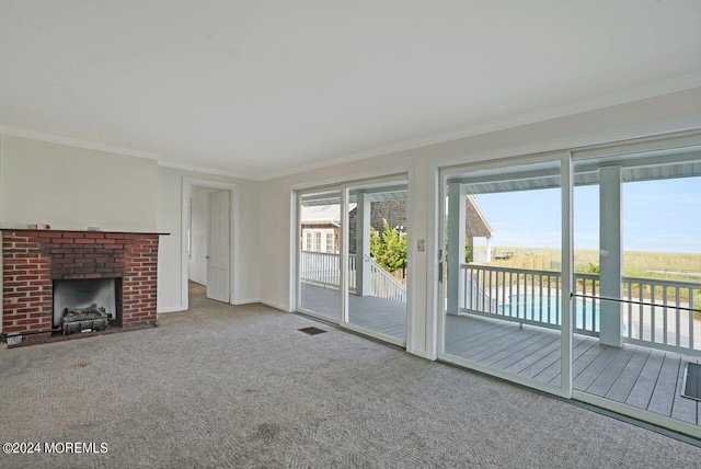 unfurnished living room with ornamental molding, carpet, and a brick fireplace