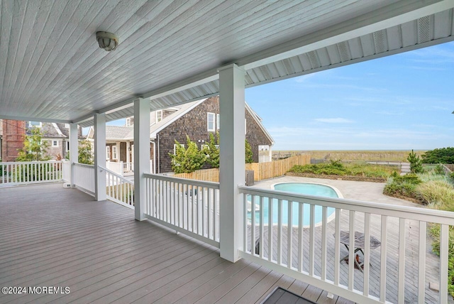 wooden terrace with a patio and a fenced in pool