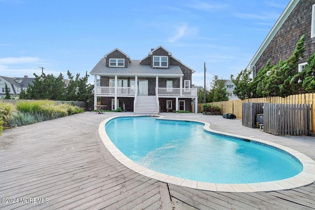 view of swimming pool featuring a deck and a sunroom