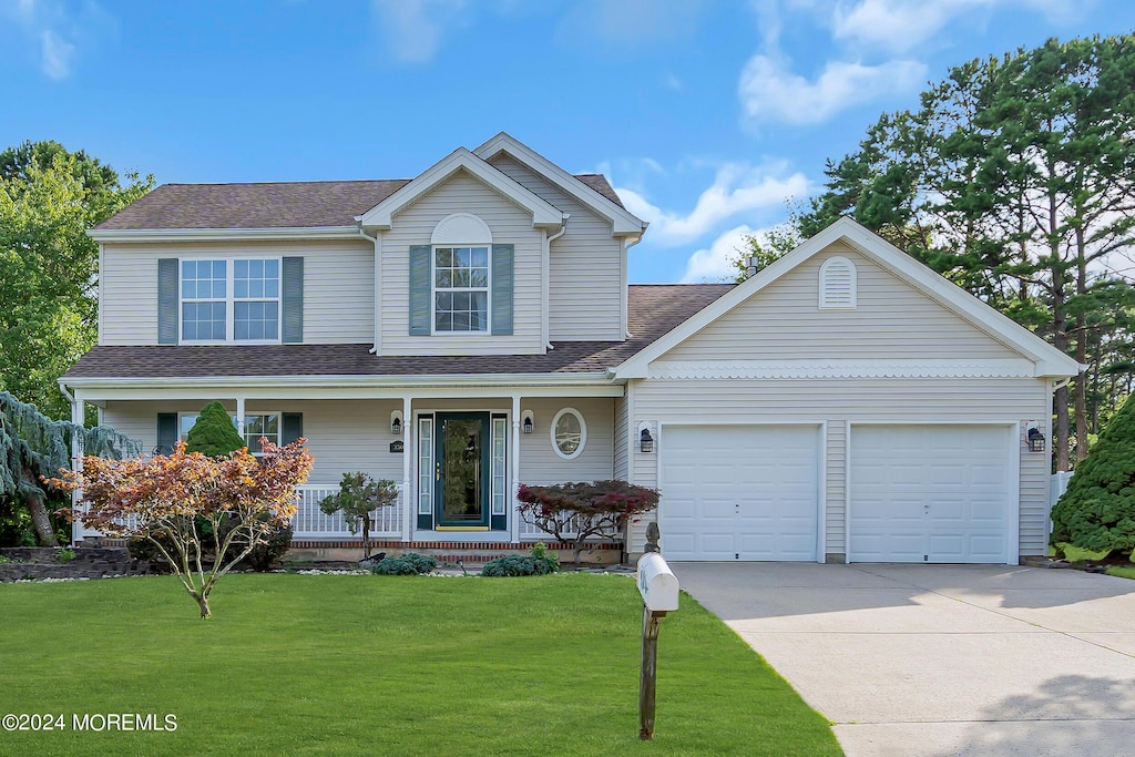 view of front property with a garage, a porch, and a front lawn