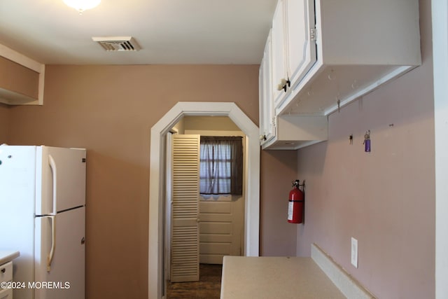 kitchen featuring white cabinetry and white fridge