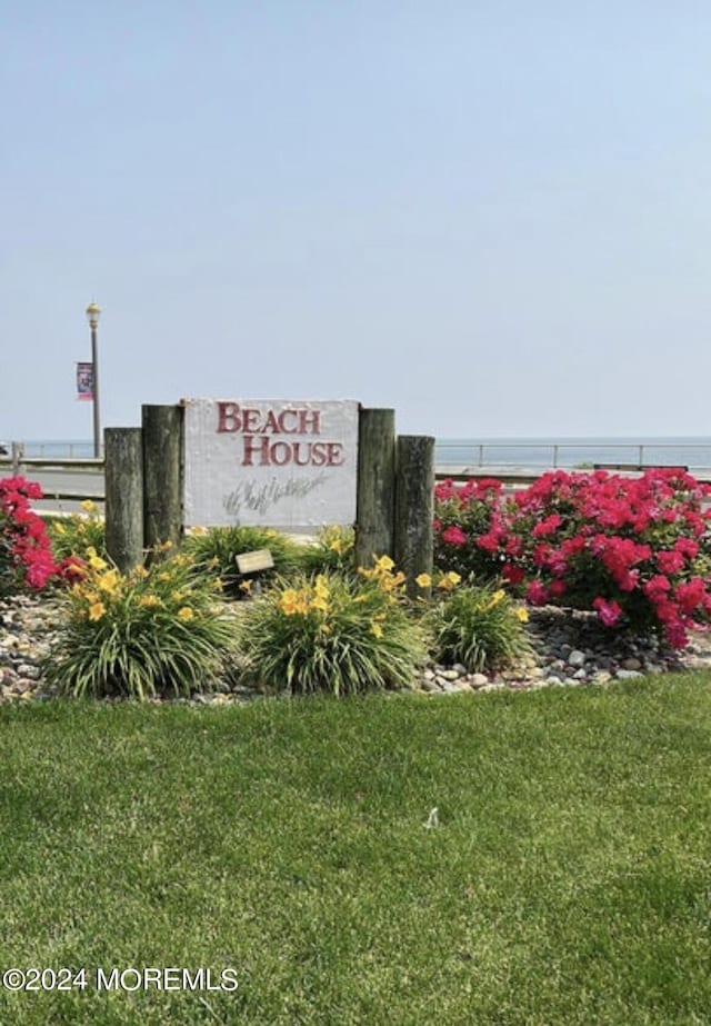 community / neighborhood sign with a yard and a water view