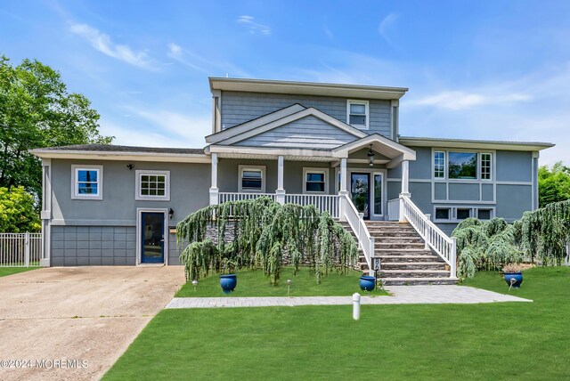 view of front of property with a garage, covered porch, and a front yard