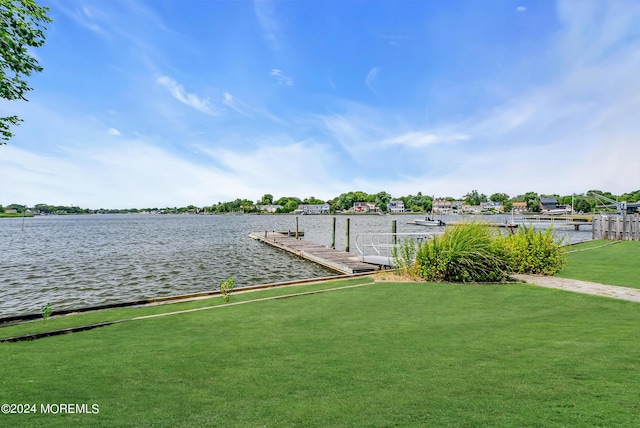 dock area featuring a water view and a lawn