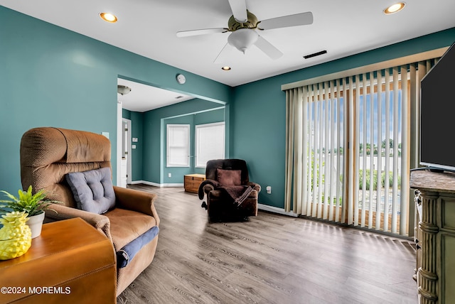 living area featuring hardwood / wood-style flooring and ceiling fan