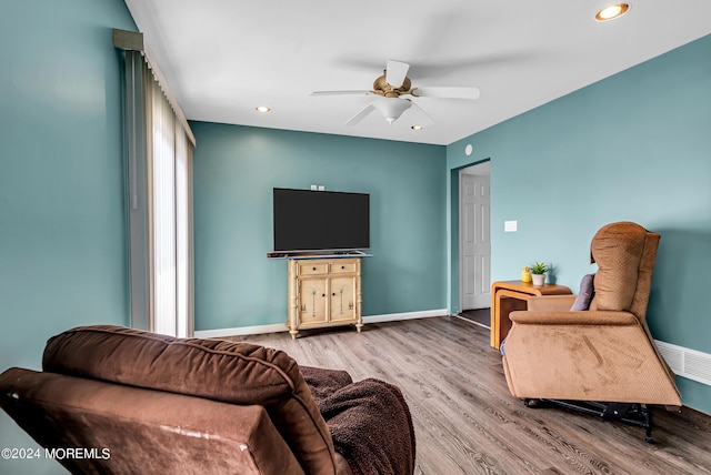 living room with hardwood / wood-style flooring and ceiling fan